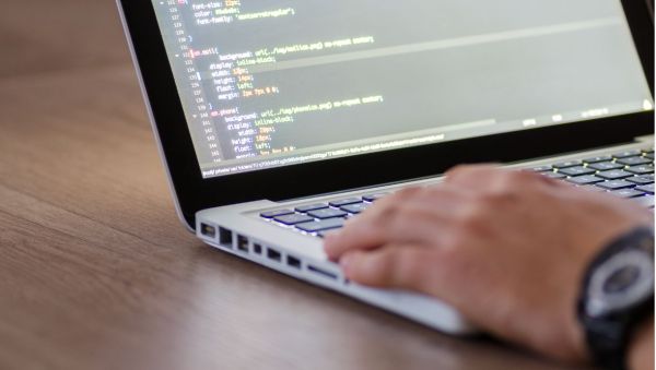 Man working on a laptop coding a website